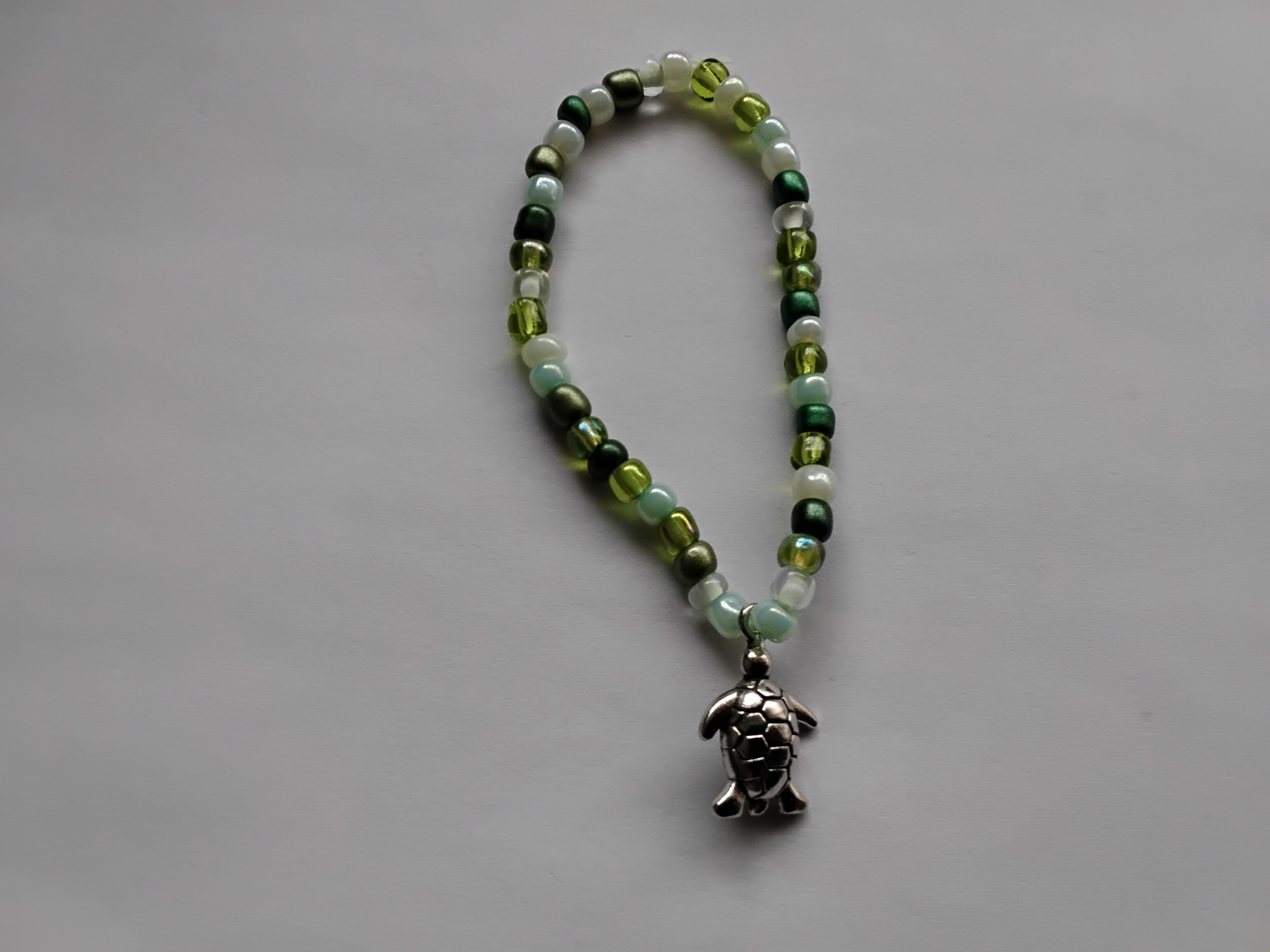 Pulsera de abalorios verde con accesorio de tortuga