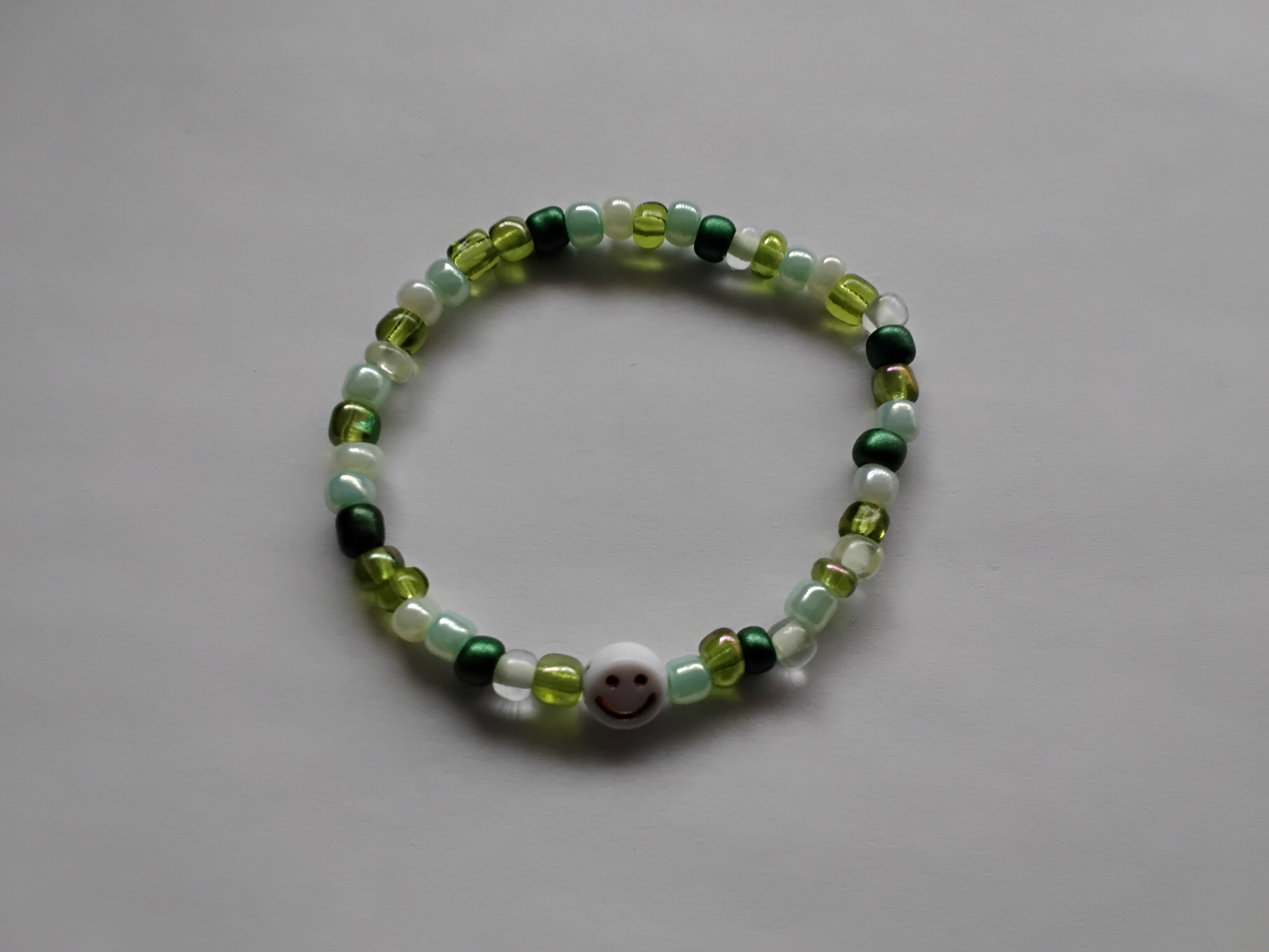 Pulsera de abalorios verdes con accesorio de sonrisa