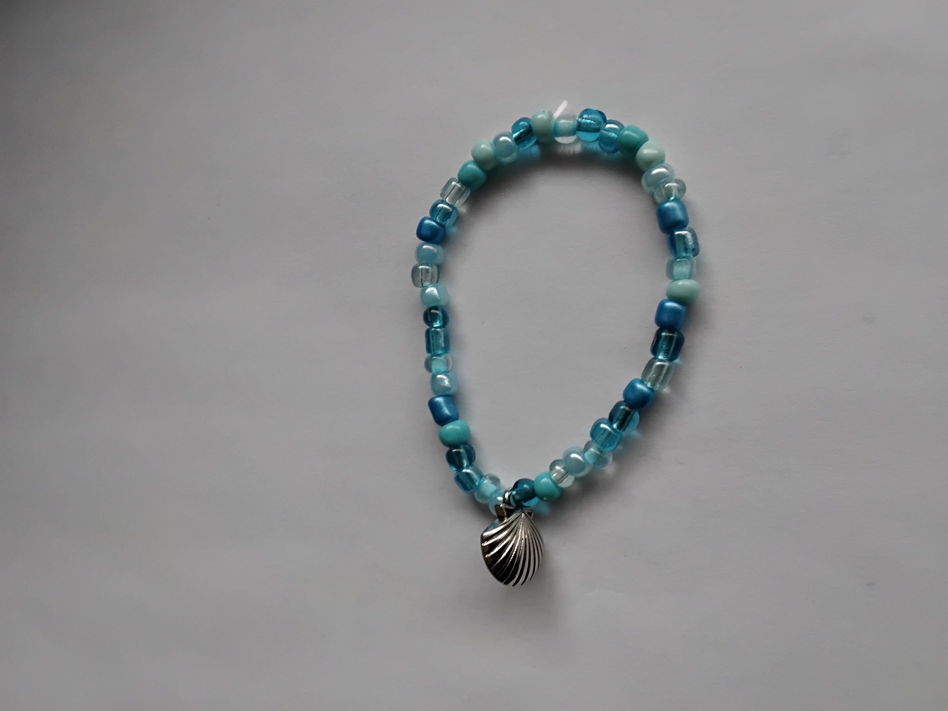 Pulsera de abalorios azules con accesorio de concha de mar